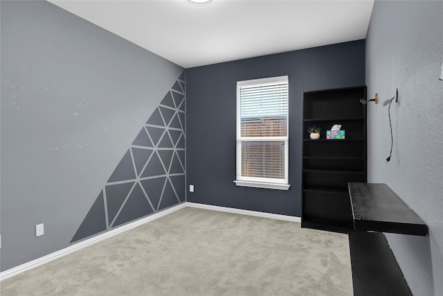 carpeted empty room with baseboards