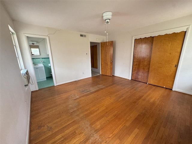 1905 Province Ln, Dallas, TX 75228 - unfurnished bedroom with visible vents, connected bathroom, wood finished floors, and a closet