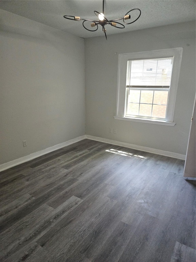 7211 Arborcrest Dr, Dallas, TX 75232 - unfurnished room featuring a chandelier, a textured ceiling, baseboards, and dark wood finished floors