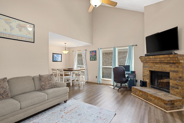 522 E Stone Cir, Wylie, TX 75098 - living room with wood finished floors, a brick fireplace, a ceiling fan, and a high ceiling