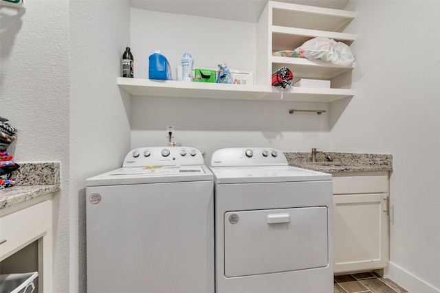 clothes washing area with light wood-style floors, cabinet space, and washing machine and dryer