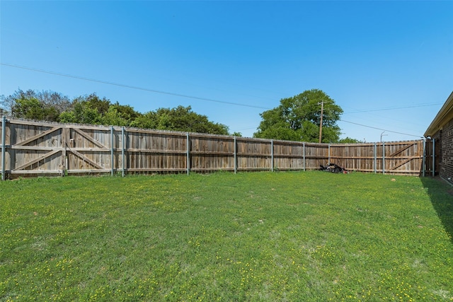 view of yard featuring a fenced backyard and a gate