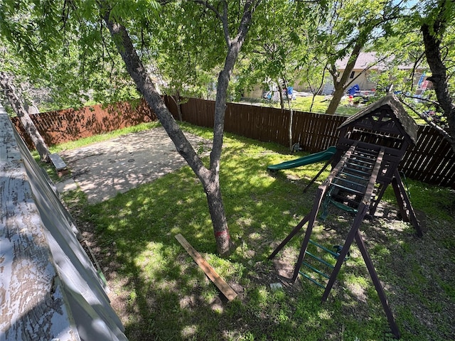 view of yard featuring fence and a playground