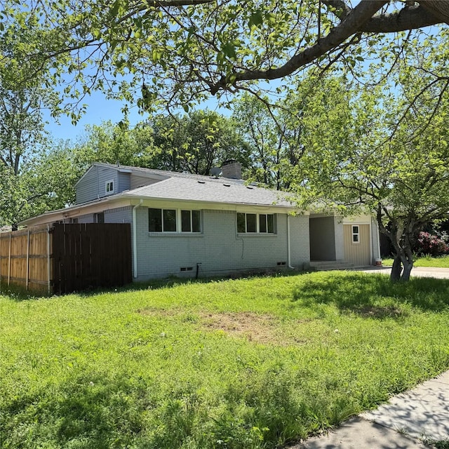exterior space featuring a chimney, crawl space, a front lawn, brick siding, and fence