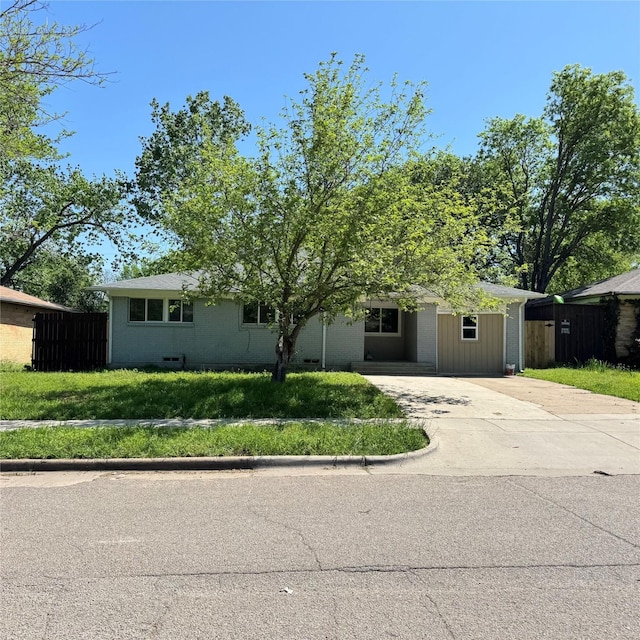 ranch-style house with driveway, a front yard, and fence
