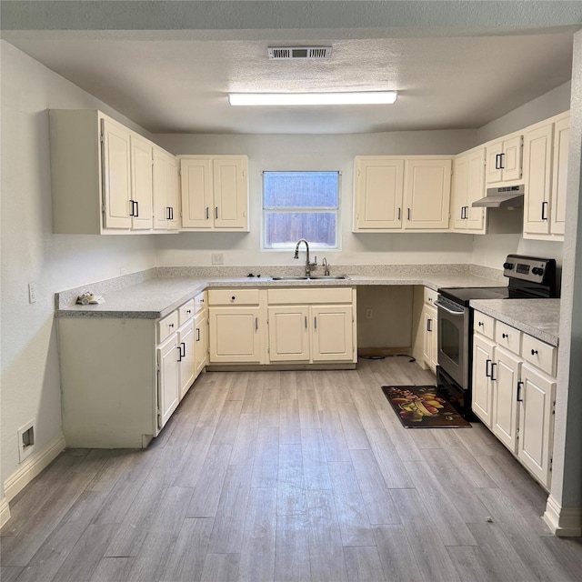 kitchen featuring light wood-style floors, electric range, visible vents, under cabinet range hood, and a sink