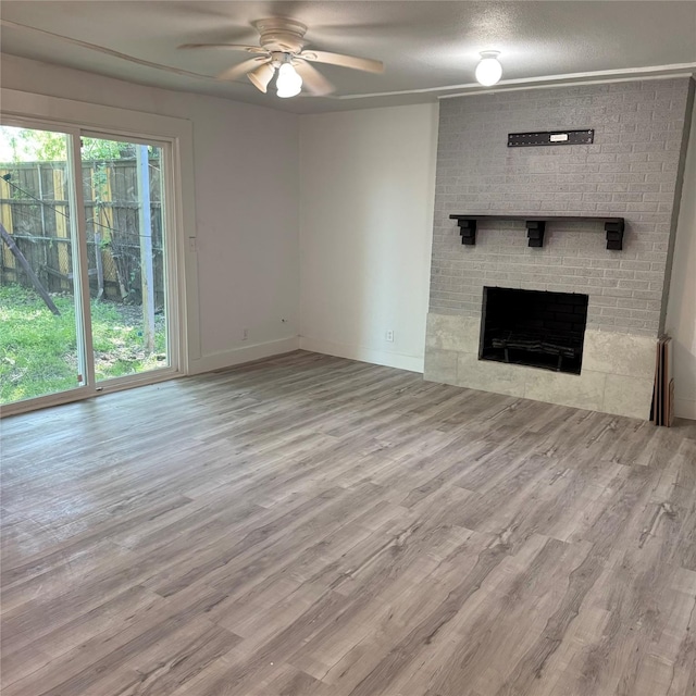 unfurnished living room with a fireplace, radiator heating unit, a ceiling fan, wood finished floors, and baseboards