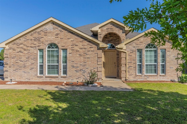 single story home with a front yard and brick siding