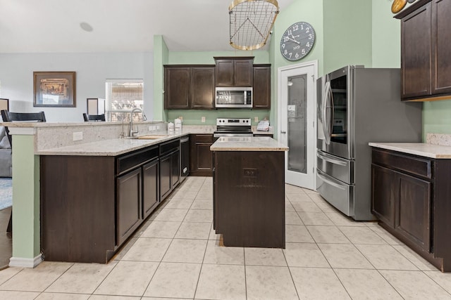 6517 Sierra Madre Dr, Fort Worth, TX 76179 - kitchen featuring a kitchen island, appliances with stainless steel finishes, dark brown cabinets, a sink, and a peninsula