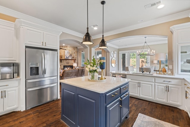 901 Moss Glen Dr, Prosper, TX 75078 - kitchen with a sink, blue cabinets, arched walkways, stainless steel refrigerator with ice dispenser, and visible vents