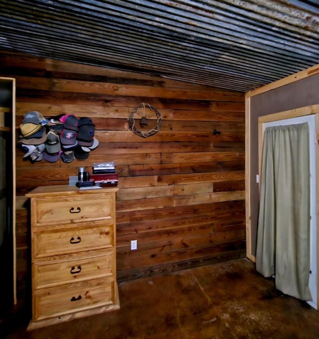 interior space featuring concrete floors and wooden walls