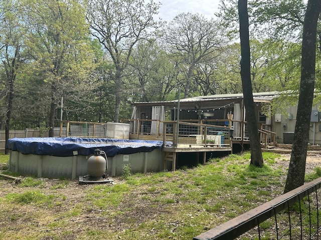 exterior space with a wooden deck, a covered pool, and fence