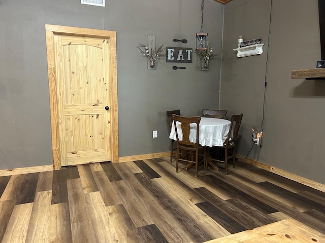 dining space featuring wood finished floors and baseboards