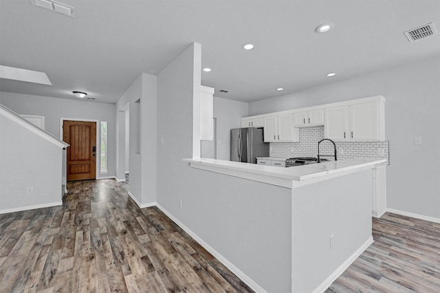 kitchen featuring visible vents, wood finished floors, and freestanding refrigerator