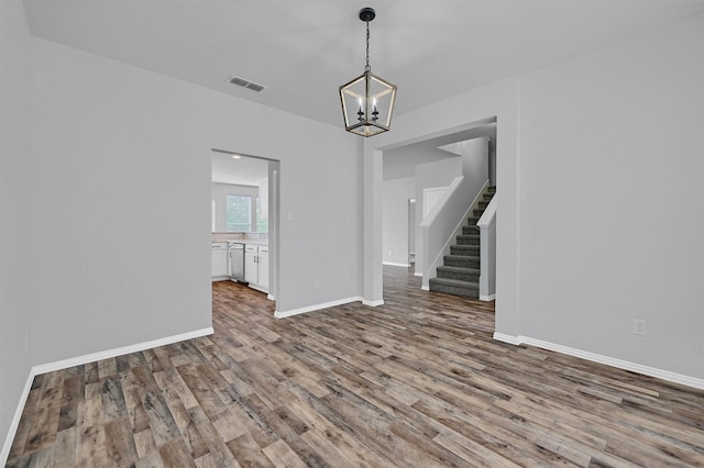 interior space featuring a chandelier, visible vents, wood finished floors, and stairs