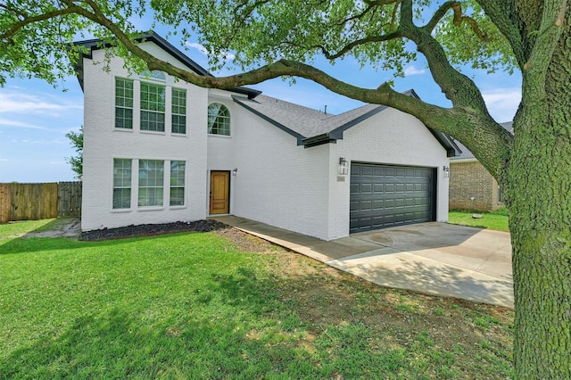 view of front facade featuring a front yard, a garage, driveway, brick siding, and fence