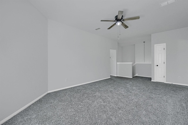 empty room featuring visible vents, dark colored carpet, ceiling fan, and baseboards