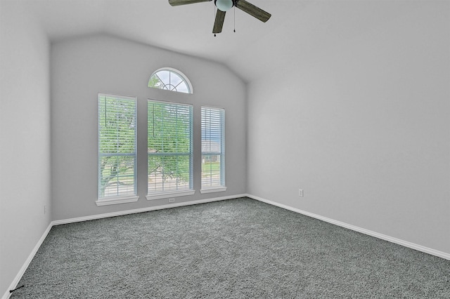 empty room with carpet flooring, ceiling fan, lofted ceiling, and baseboards