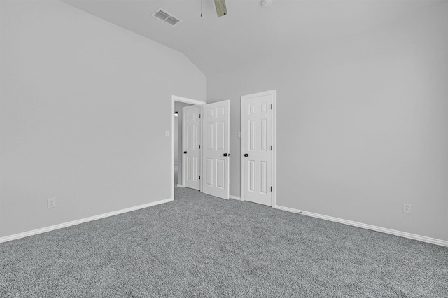 spare room with carpet flooring, visible vents, vaulted ceiling, and baseboards