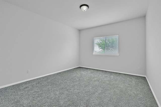 unfurnished room featuring baseboards and carpet