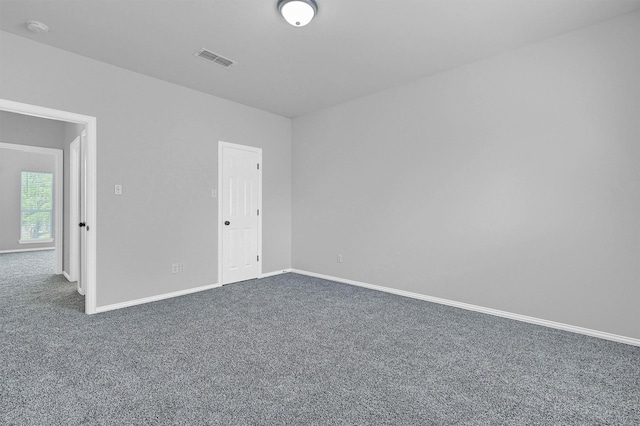 unfurnished room with baseboards, visible vents, and carpet floors