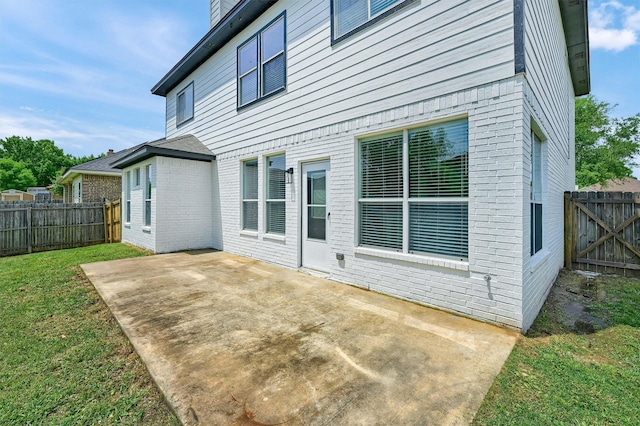 rear view of property featuring a lawn, a patio, and a fenced backyard