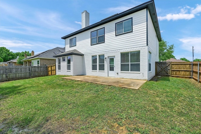 rear view of property featuring a chimney, a fenced backyard, a lawn, and a patio area