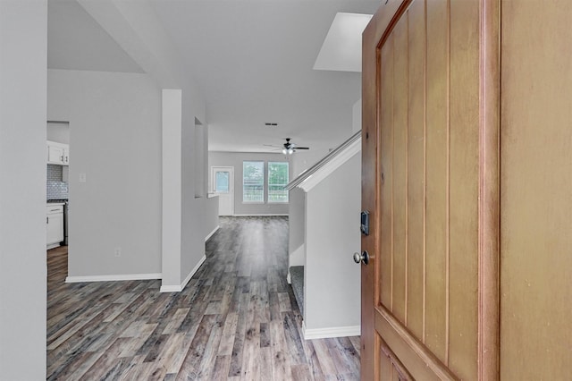 hall with baseboards and wood finished floors