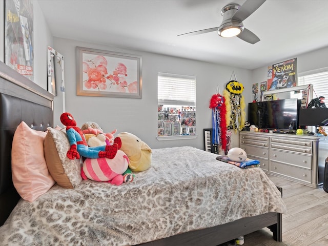 bedroom featuring ceiling fan, multiple windows, and wood finished floors