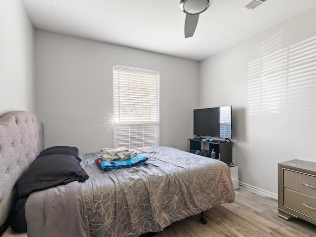bedroom with a ceiling fan, baseboards, visible vents, and light wood-style floors