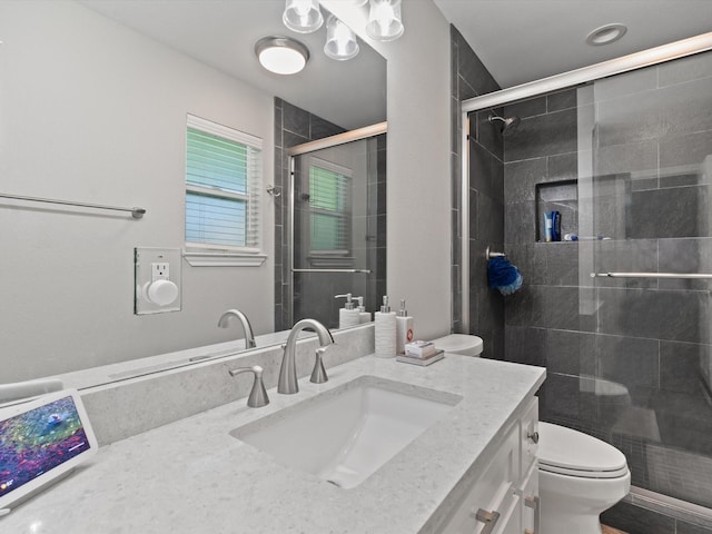 full bathroom with vanity, a shower stall, and toilet