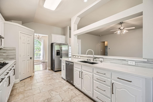kitchen with appliances with stainless steel finishes, a sink, light countertops, white cabinets, and lofted ceiling