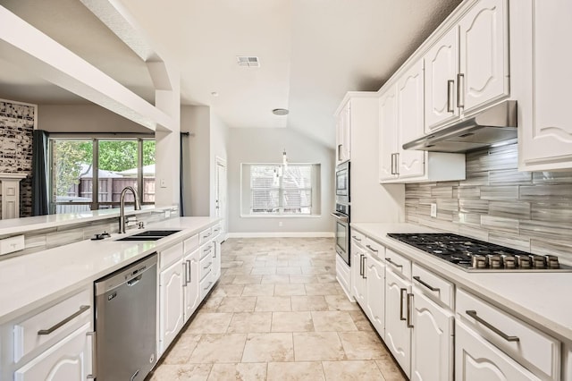 kitchen with backsplash, appliances with stainless steel finishes, a sink, under cabinet range hood, and white cabinetry