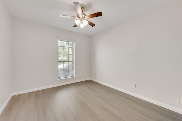 spare room featuring baseboards, a ceiling fan, and wood finished floors