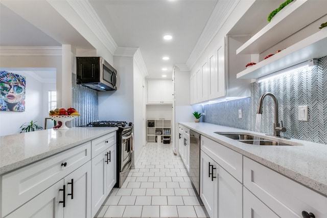 kitchen with crown molding, open shelves, white cabinets, a sink, and appliances with stainless steel finishes