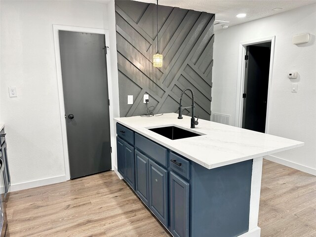10035 Everton Pl, Dallas, TX 75217 - kitchen with light wood-style flooring, a peninsula, blue cabinets, a sink, and baseboards