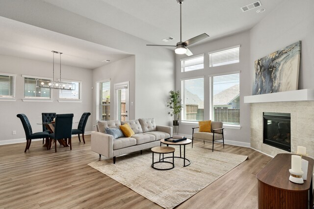 living area featuring baseboards, light wood finished floors, a fireplace, and visible vents