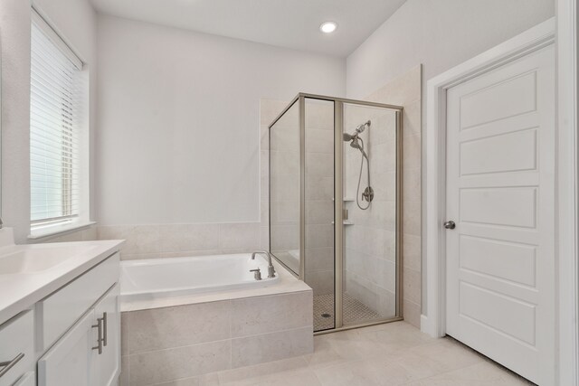 full bathroom featuring a bath, a stall shower, vanity, and tile patterned flooring