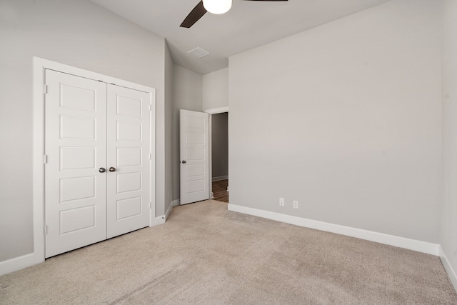 unfurnished bedroom featuring visible vents, baseboards, a closet, ceiling fan, and carpet flooring