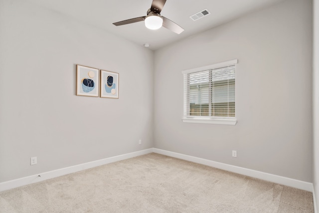 unfurnished room featuring baseboards, light colored carpet, ceiling fan, and visible vents