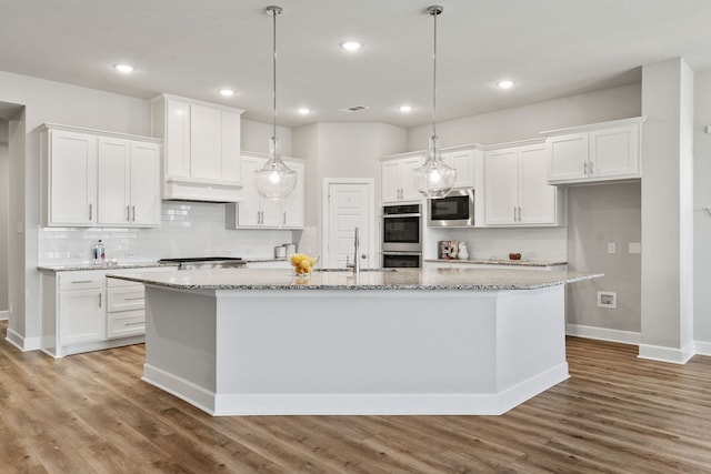 kitchen featuring wood finished floors, white cabinets, and stainless steel appliances