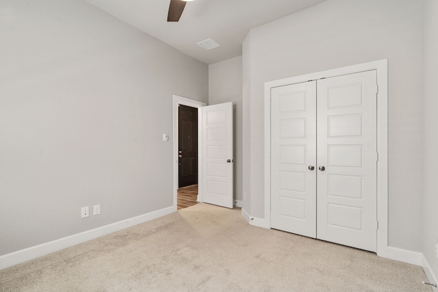 unfurnished bedroom featuring carpet, a closet, a ceiling fan, visible vents, and baseboards