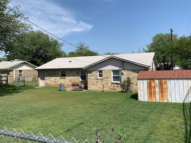 824 Opal St, Saginaw, TX 76179 - rear view of property with a storage shed, an outdoor structure, a lawn, fence, and brick siding