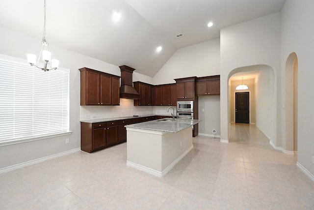 kitchen featuring stainless steel appliances, an inviting chandelier, a sink, arched walkways, and custom range hood