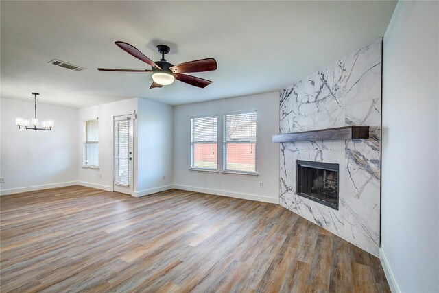 2023 Lake Trail Dr, Heartland, TX 75126 - unfurnished living room featuring ceiling fan with notable chandelier, visible vents, wood finished floors, a premium fireplace, and baseboards