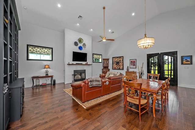 dining room featuring a brick fireplace, recessed lighting, french doors, dark wood finished floors, and ceiling fan with notable chandelier