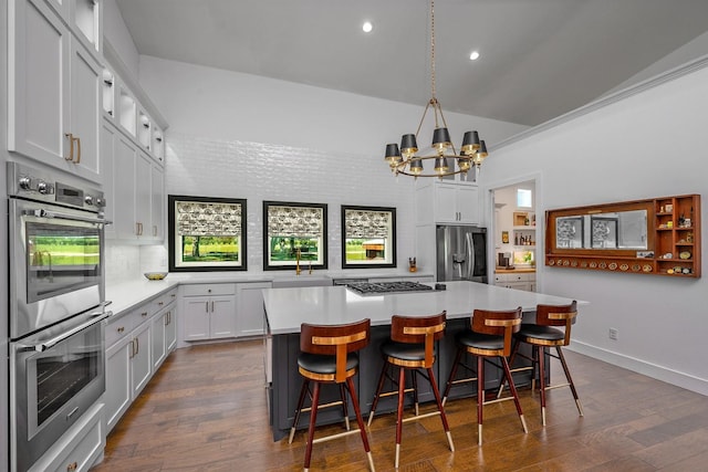 kitchen featuring backsplash, appliances with stainless steel finishes, a sink, light countertops, and recessed lighting