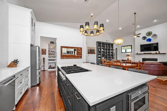 kitchen featuring appliances with stainless steel finishes, a kitchen island, white cabinetry, and open floor plan