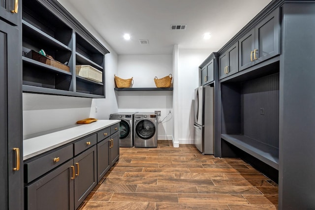laundry area with washing machine and clothes dryer, recessed lighting, visible vents, and dark wood finished floors