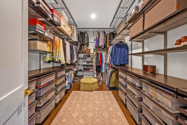 spacious closet with dark wood-style floors
